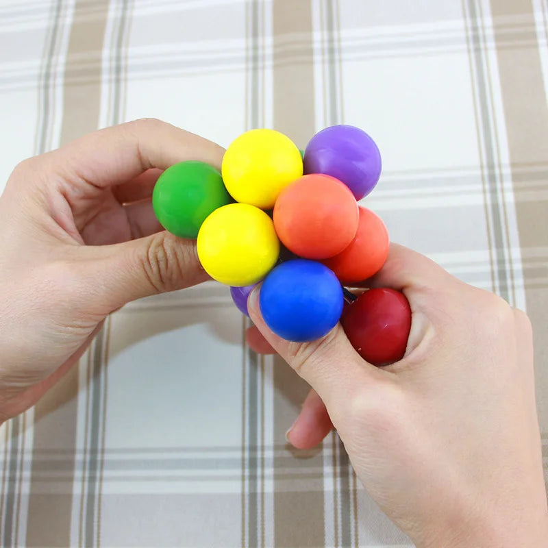 Colorful stress relief toy being squeezed between two hands for sensory fun and relaxation
