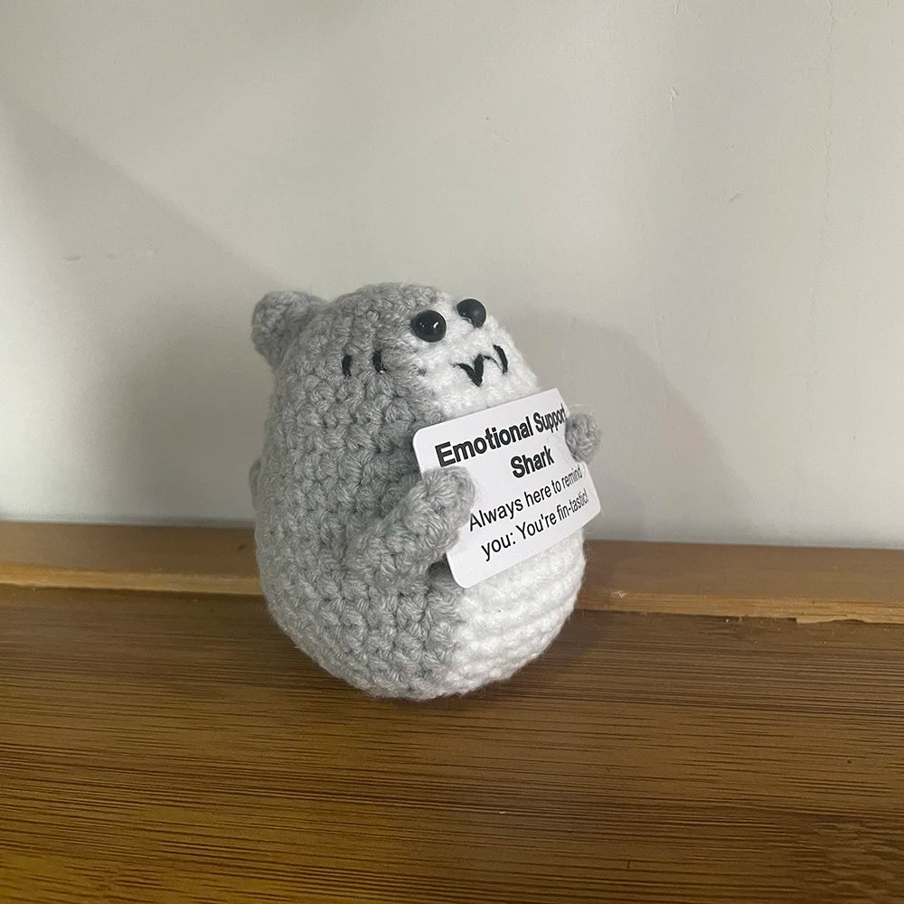 Handmade crochet emotional support buddies in the form of a cute shark toy with a supportive message