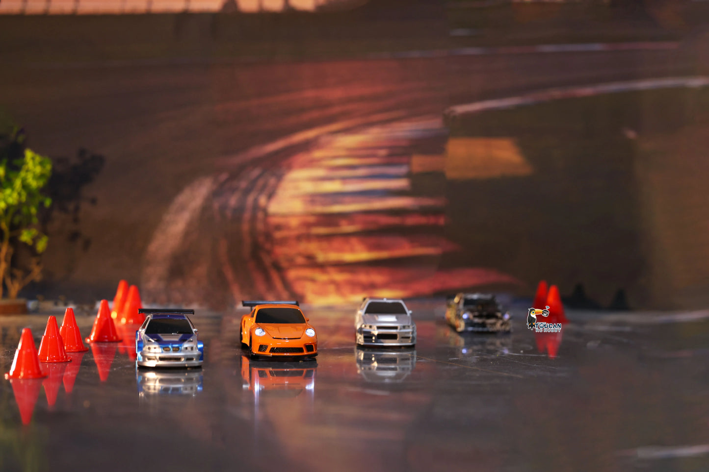 Collection of radio control drifting cars lined up on a racetrack with orange traffic cones