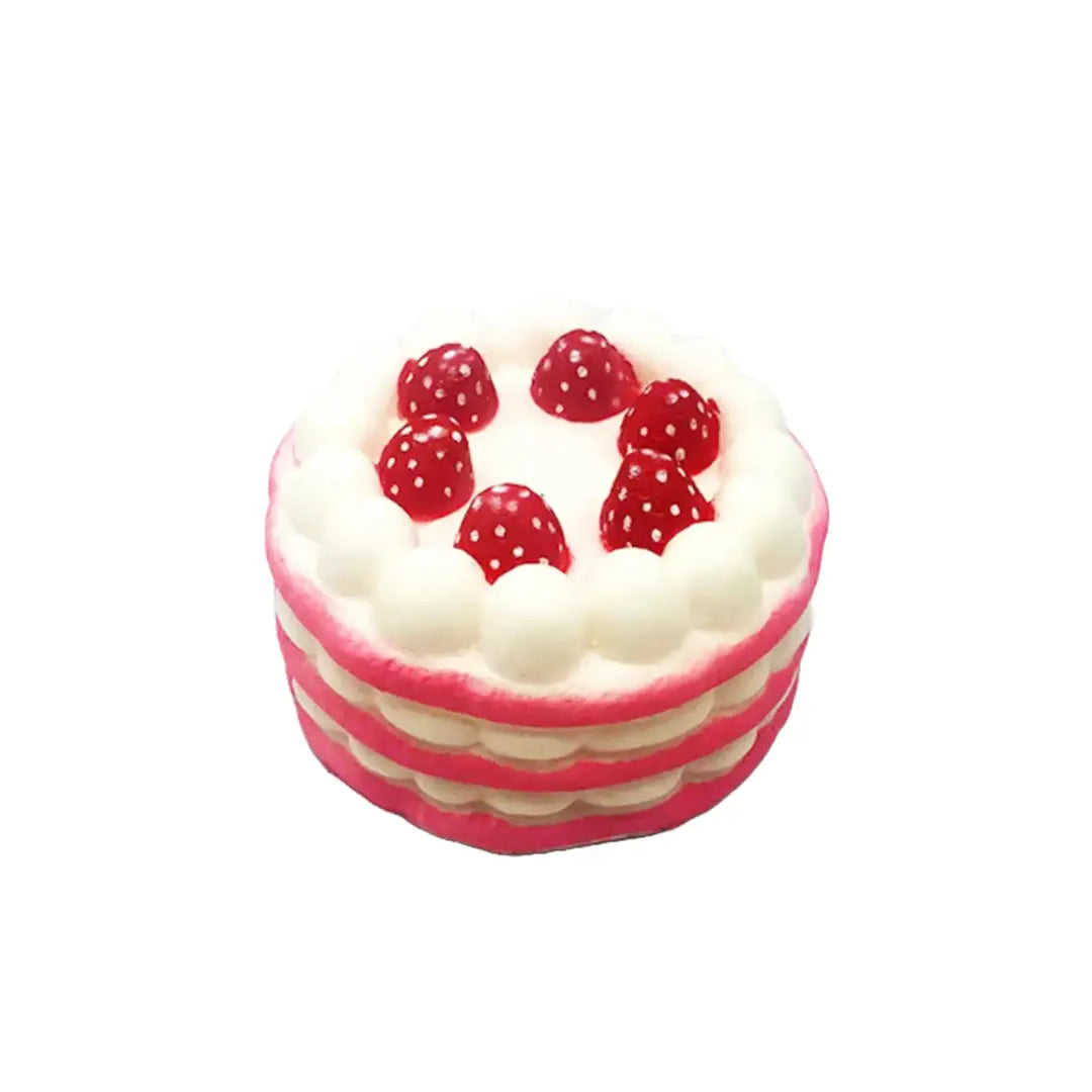 A colorful cake with three layers, topped with whipped cream and six bright red strawberries adorned with white polka dots.