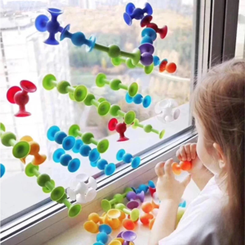 Child playing with a colorful suction cup dart set on a window, featuring vibrant suction cups in various colors