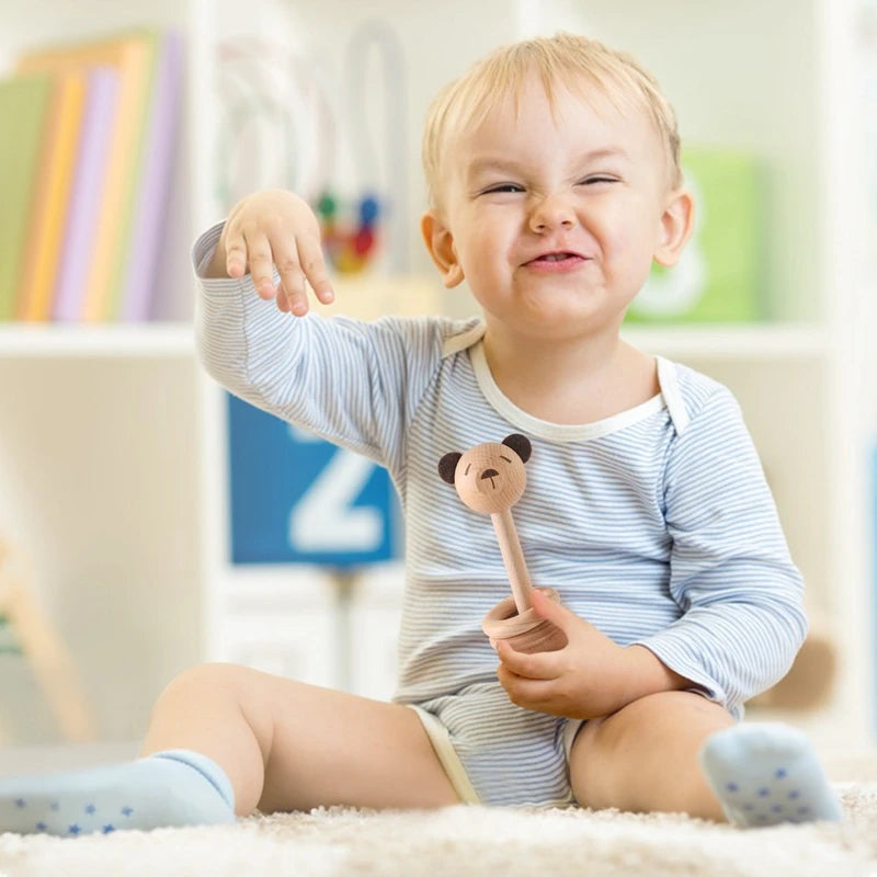 Happy baby playing with therapeutic baby rattles for sensory development and soothing