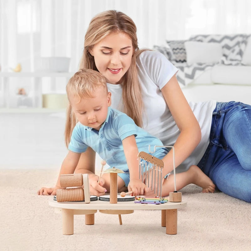 Child and caregiver playing with wooden mini band stand toy promoting creativity and motor skills