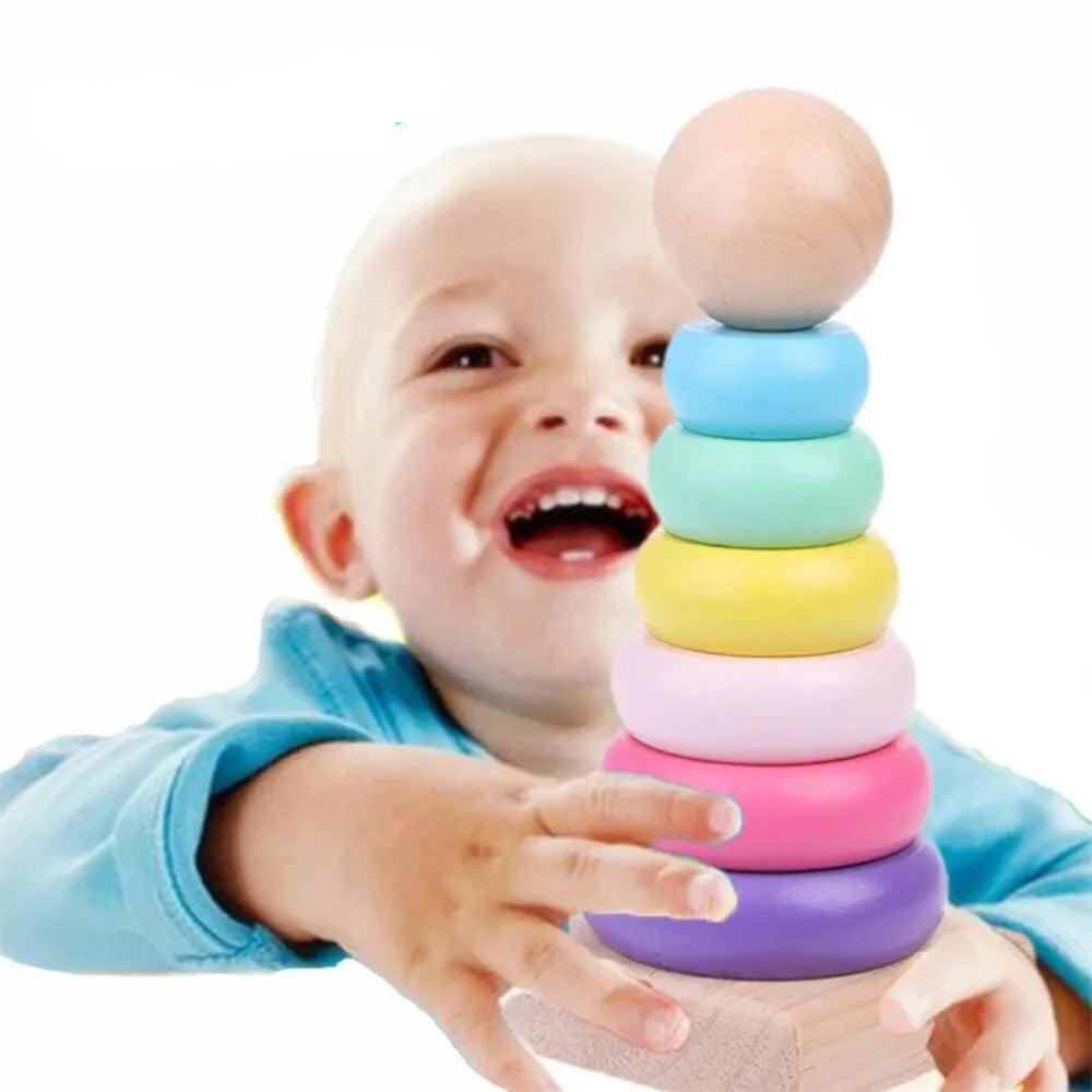 Child playing with a colorful wooden rainbow stacking tower for developing fine motor skills