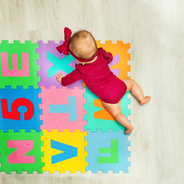 Baby crawling on colorful foam tiles showcasing the benefits of baby play mats for early development