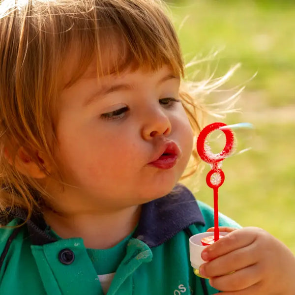 Toddler blowing soap bubbles