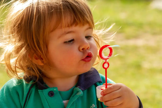 Toddler blowing soap bubbles