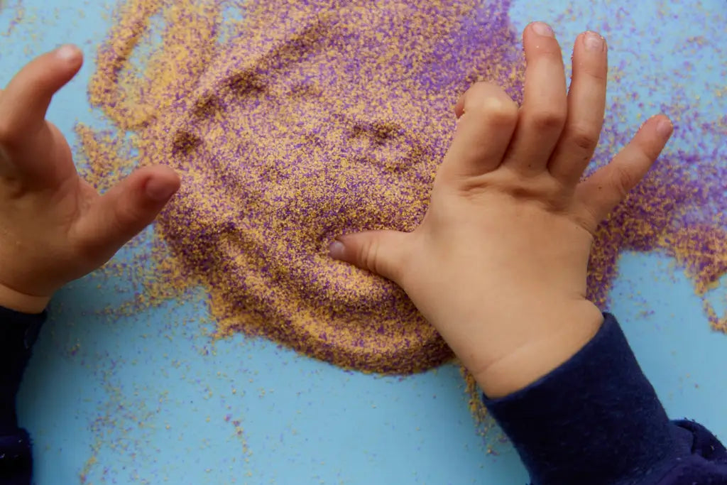 Childs hands playing in sand