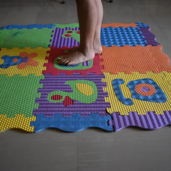 Person standing barefoot on colorful foam play mat highlighting common baby play mat mistakes