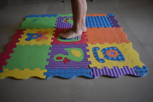 Person standing barefoot on colorful foam play mat highlighting common baby play mat mistakes