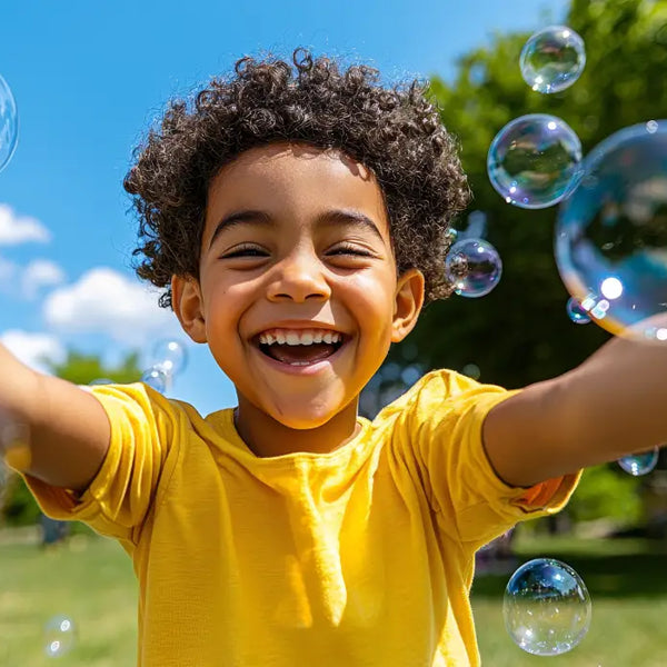 Laughing toddler chasing bubbles across a sunny lawn