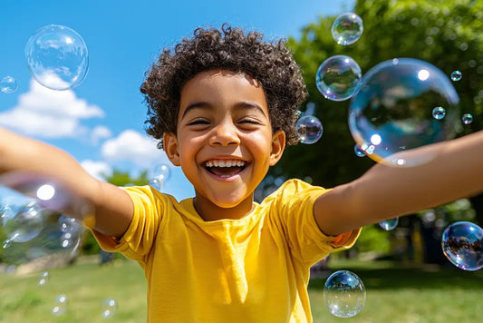 Laughing toddler chasing bubbles across a sunny lawn