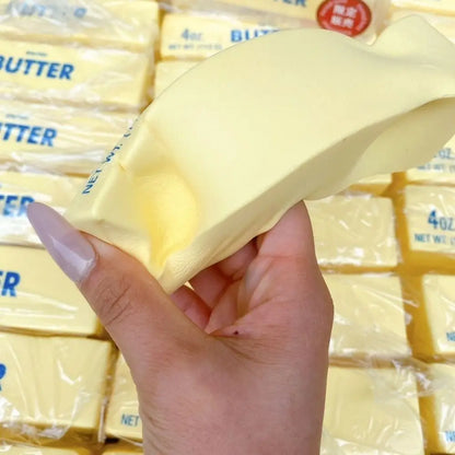Hand squeezing a slow-rising butter squishy stick