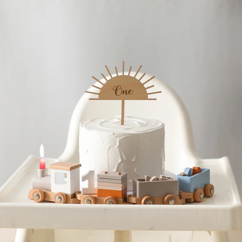 Classic wooden train toy centerpiece on a cake for a child's first birthday celebration