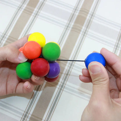 Colorful stress relief toy featuring vibrant balls connected by elastic cords for sensory play