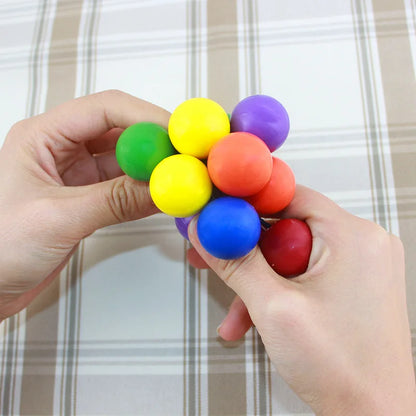 Colorful stress relief toy being squeezed between two hands for sensory fun and relaxation