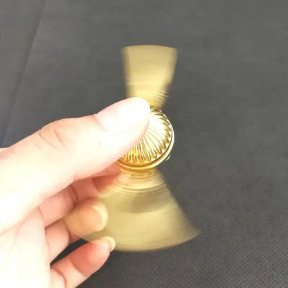 Person holding a gold magic fidget spinner spinning smoothly for stress relief and focus
