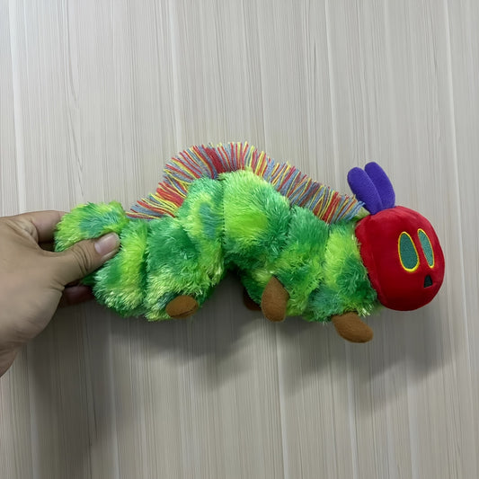 Active Playthings green caterpillar plush toy with red head and colorful yarn antennae held by hand
