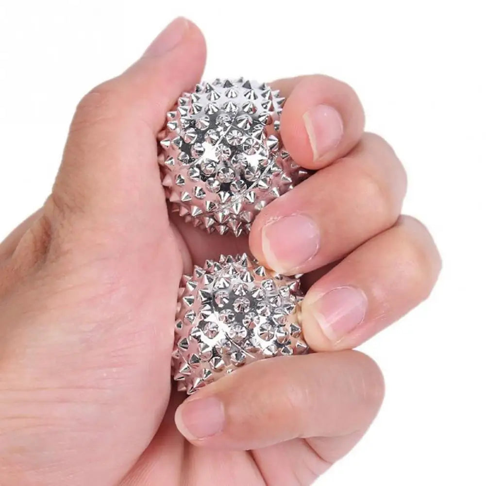 Person squeezing two spiky magnetic acupoint massage balls for stress relief and relaxation