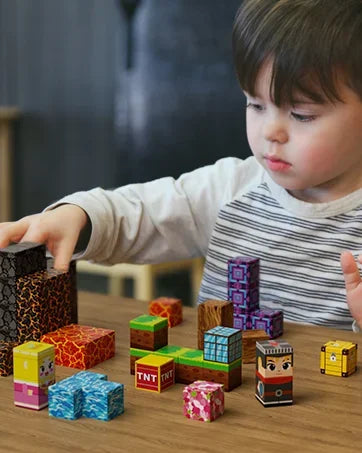 Child playing with colorful magnetic building blocks set on a wooden table