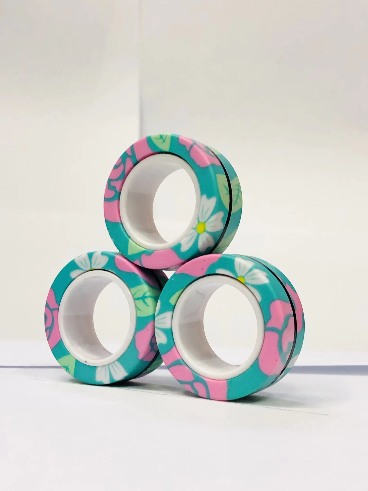 Colorful floral magnetic finger ring fidget toy stacked in a fun arrangement for stress relief