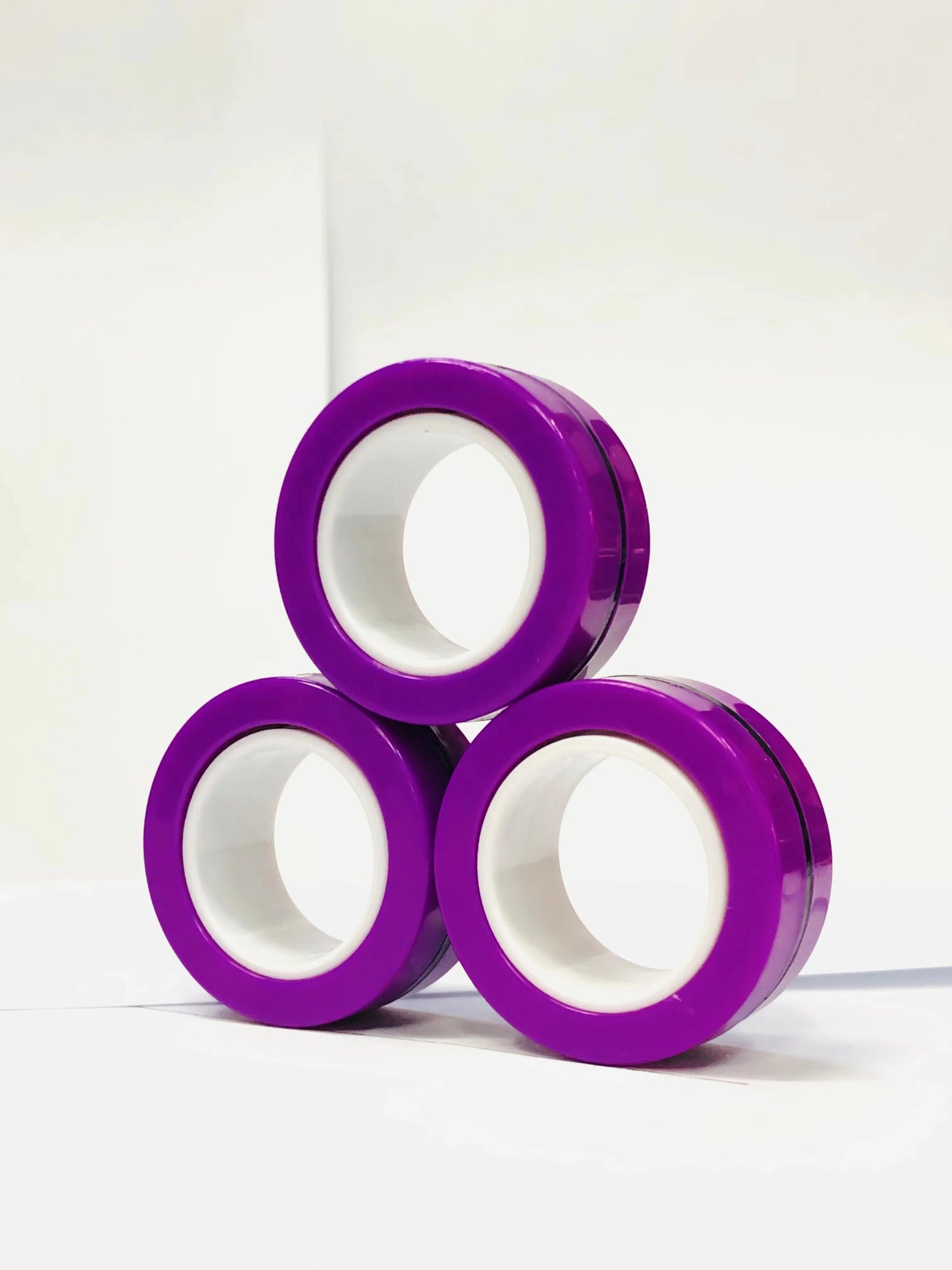Three purple magnetic finger ring fidget toys stacked for stress relief and sensory fun