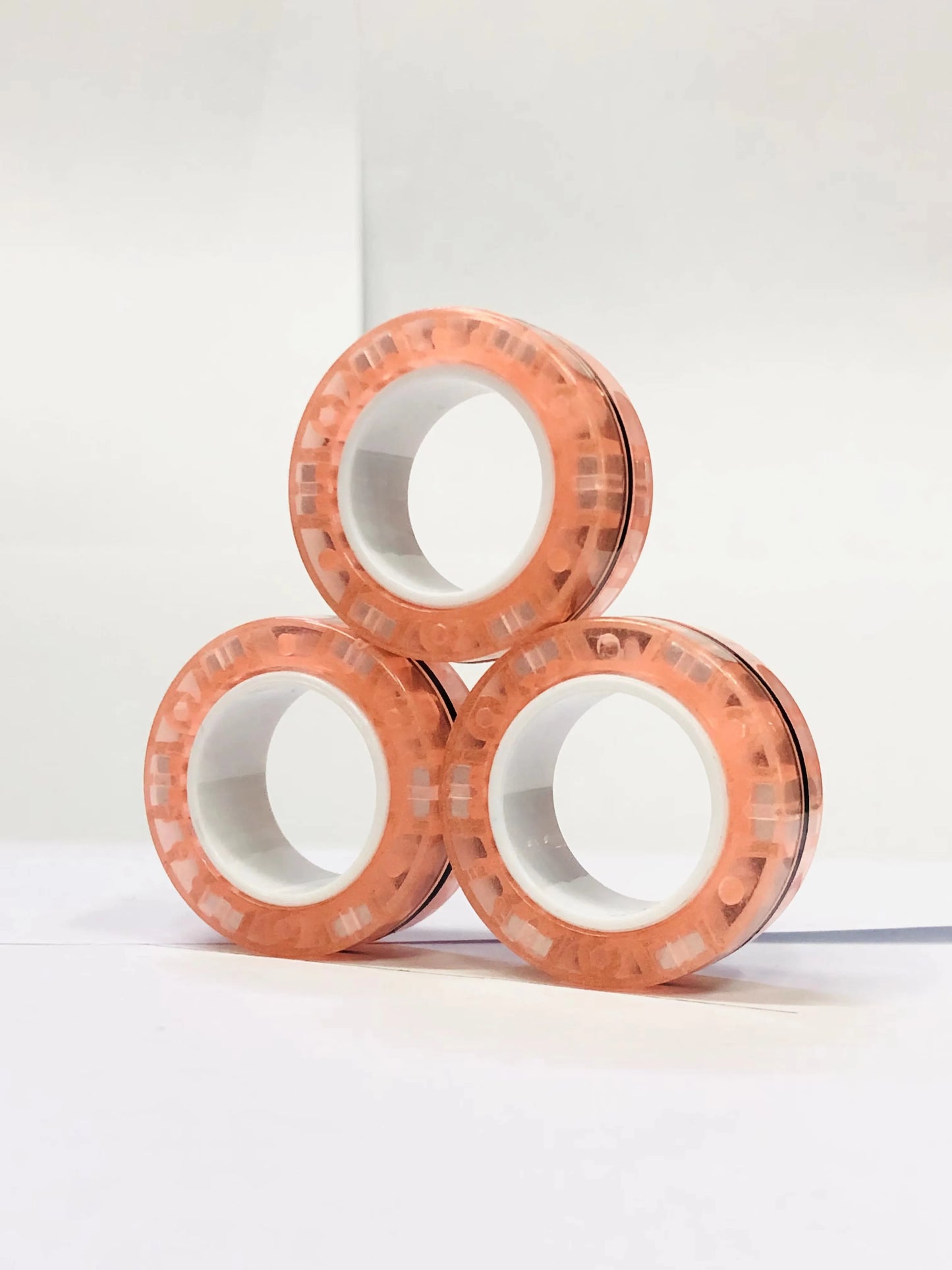 Set of three peach-colored magnetic finger ring fidget toys designed for stress relief and focus