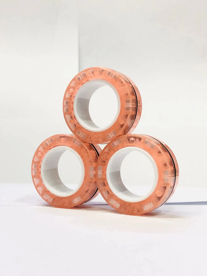 Set of three peach-colored magnetic finger ring fidget toys designed for stress relief and focus