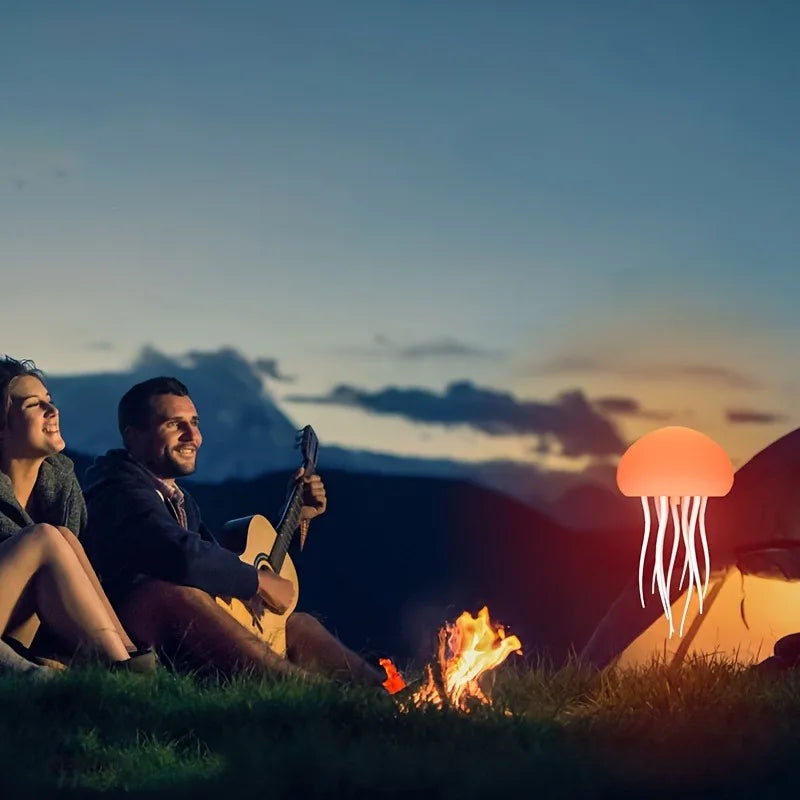 Sensory jellyfish night light illuminating a campsite with a couple enjoying music by the fire