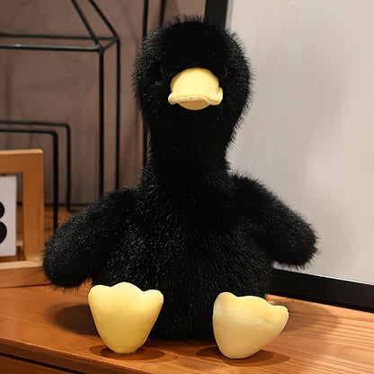 Black snuggly duck plush toy with soft yellow beak and feet on wooden surface from Active Playthings