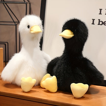 White and black snuggly duck plush toy with soft yellow beak and feet sitting on a wooden surface
