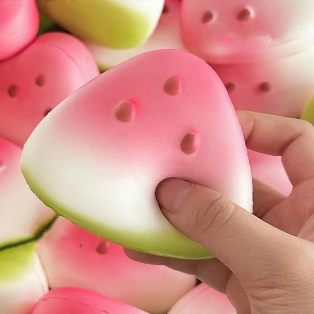 Hand squeezing a squishy watermelon stress toy with vibrant colors and soft texture