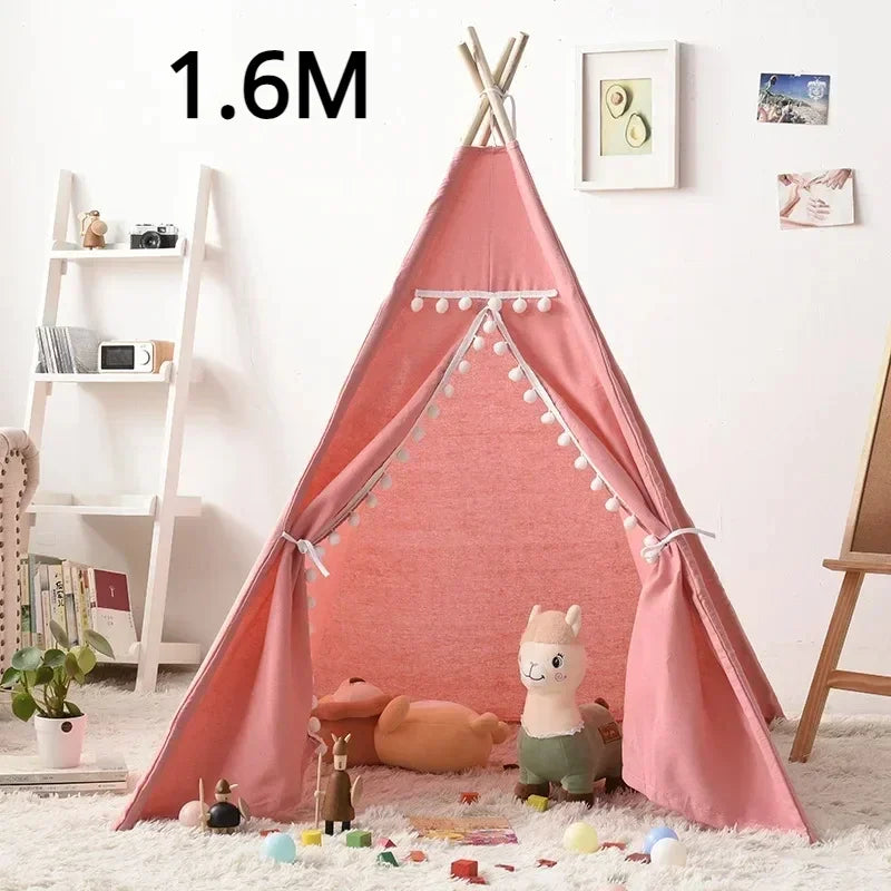 Pink teepee play tent for children with decorative pom poms and space for toys