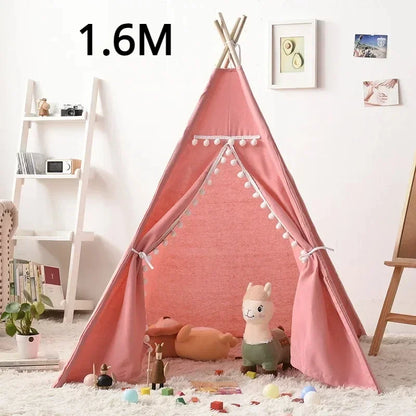 Pink teepee play tent for children with decorative pom poms and space for toys
